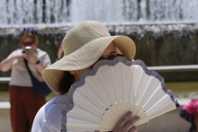 Turistka sa osviežuje vejárom pri fontáne. FOTO: TASR/AP