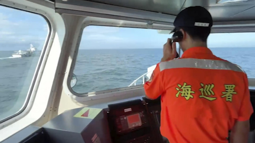 Člen posádky taiwanskej pobrežnej stráže hovorí cez megafón k posádke lode čínskej pobrežnej stráže neďaleko pobrežia pri taiwanskom okrese Kinmen. FOTO: TASR/AP