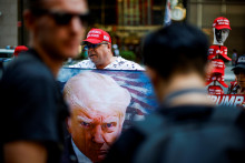 Fanúšik Donalda Trumpa drží exprezidentovu podobizeň. Svojmu politickému favoritovi prišiel vyjadriť priazeň pod Trump Tower. FOTO: Reuters