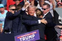Zakrvavený Donald Trump gestikuluje smerom k svojim priaznivcom krátko po tom, ako prežil pokus o atentát v Pensylvánii. FOTO: Reuters