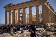 Turista prechádza okolo chrámu Parthenon na Akropoli uprostred vysokých teplôt v gréckych Aténach. FOTO: REUTERS