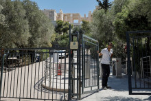 Zamestnanec zatvára bránu Akropoly po jej dočasnom zatvorení z dôvodu novej vlny horúčav v Aténach. FOTO: Reuters