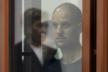 Americký novinár denníka Wall Street Journal Evan Gershkovich stojí počas čítania rozsudku v súdnej sieni v Jekaterinburgu. FOTO: TASR/AP