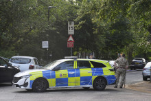 Muž vo vojenskej uniforme stojí pri policajnom aute po útoku 24-ročného muža, ktorý dobodal vojaka na ulici neďaleko kasární v meste Gillingham v juhovýchodnom Anglicku. FOTO: TASR/AP