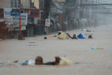 Ľudia sa brodia zaplavenou cestou po silných dažďoch, ktoré priniesol tajfún Kaemi vo filipínskej Manile. FOTO: Reuters