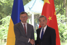 Ukrajinský minister zahraničných vecí Dmytro Kuleba (vľavo) a jeho čínsky rezortný kolega Wang I pózujú počas stretnutia v meste Kuang-čou na juhu Číny. FOTO: TASR/AP