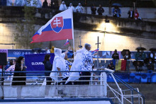 Vlajkonosiči slovenskej výpravy - vodní slalomári Jakub Grigar a Zuzana Paňková sa vezú na lodi po rieke Seina počas otváracieho ceremoniálu XXXIII. letných olympijských hier v Paríži 26. júla 2024. FOTO: TASR