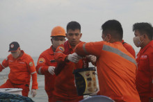 Personál filipínskej pobrežnej stráže zbiera ropu, ktorá je súčasťou škvŕn z paliva, ktoré poháňalo nádrž, aby sa zabránilo jej šíreniu blízko východne od Lamao Point. FOTO: TASR/AP