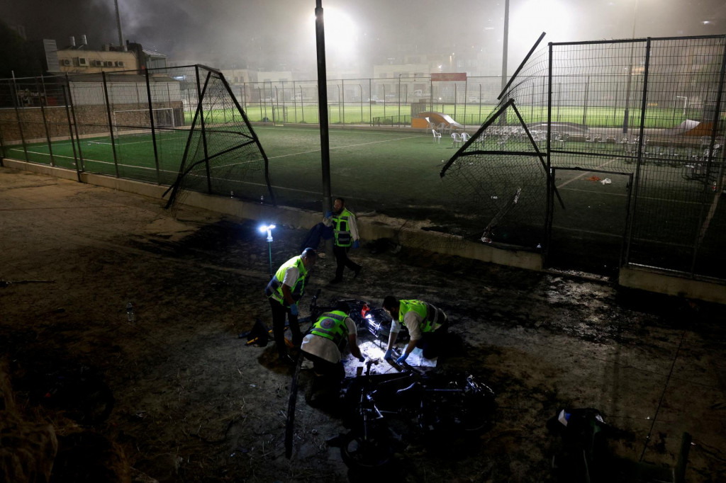 Pohotovostný personál kontroluje oblasť po odpálení rakiet cez libanonskú hranicu v Majdal Shams. FOTO: Reuters