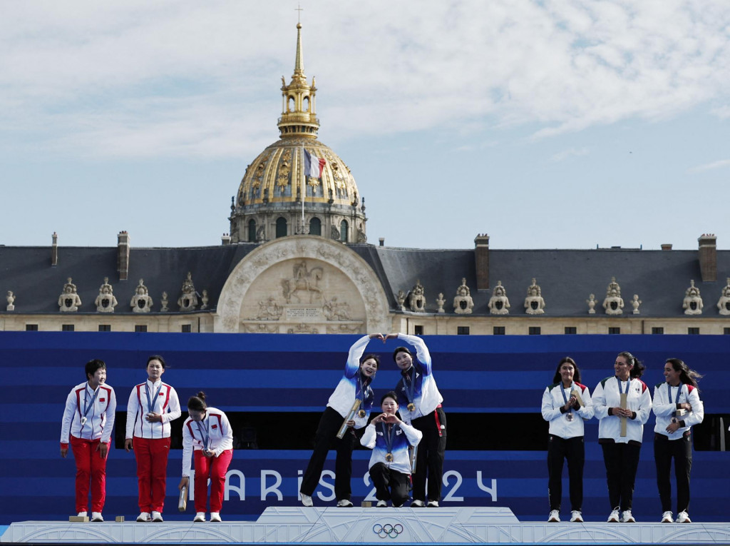 Suhyeon Nam z Južnej Kórey, Sihyeon Lim z Južnej Kórey a Hunyoung Jeon z Južnej Kórey oslavujú po zisku zlatej medaily. FOTO: Reuters