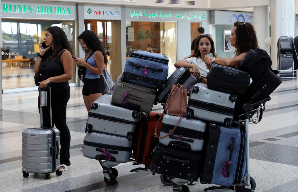 Ženy stoja pri svojej batožine pred kanceláriami Middle East Airline na medzinárodnom letisku Bejrút-Rafic Hariri v Bejrúte. FOTO: Reuters