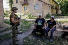 Ukrajinský vojak oboznamuje obyvateľov Torecku s plánom evakuácie. FOTO: Šuster Dusan