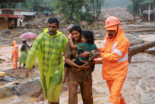 Záchranári pomáhajú obyvateľom presunúť sa na bezpečnejšie miesto po viacerých zosuvoch pôdy v indickom štáte Kerala. FOTO: Reuters