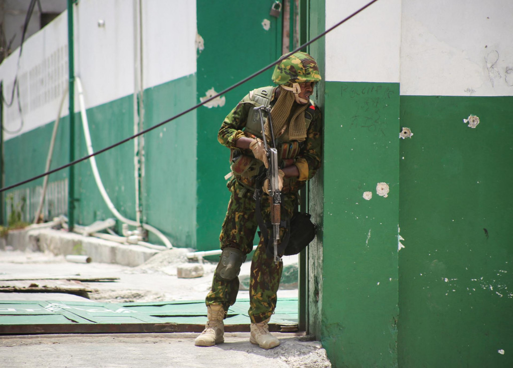 Kenský policajt stojí pred pozostatkami nemocnice počas spoločnej operácie s haitskou políciou v Port-au-Prince. FOTO: Reuters