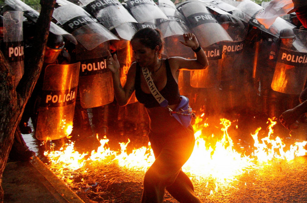 Molotovove koktaily dopadli na zem pred bezpečnostnými silami počas protestov proti výsledkom volieb vo Venezuele. FOTO: Reuters