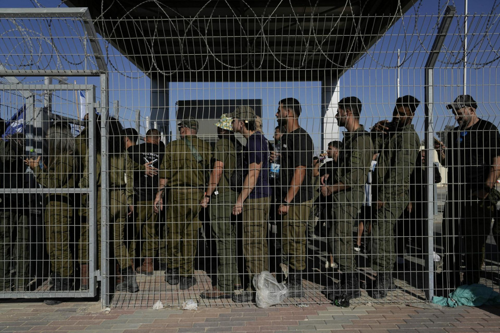 Izraelskí vojaci sa zhromažďujú pri bráne vojenskej základne Sde Teiman. FOTO: TASR/AP