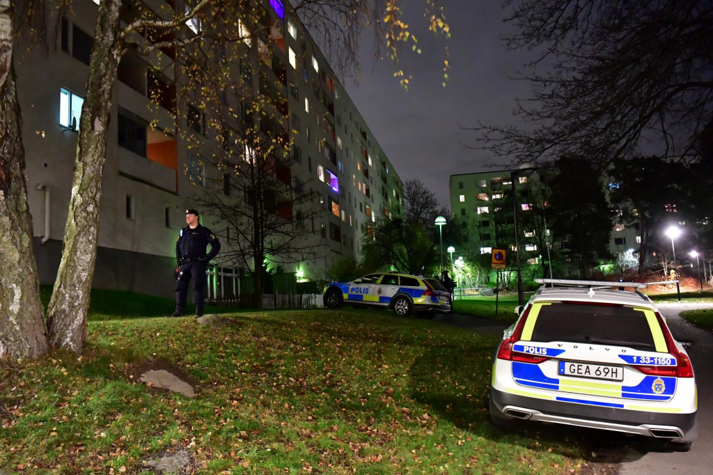 Švédsky policajt stojí vedľa policajných áut na mieste trestného činu pri bytovom dome v Štokholme. ILUSTRAČNÉ FOTO: REUTERS