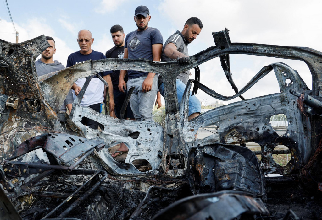 Palestínčania kontrolujú vozidlo poškodené pri izraelskom nálete neďaleko mesta Tulkarm, na Izraelom okupovanom Západnom brehu Jordánu. FOTO: Reuters