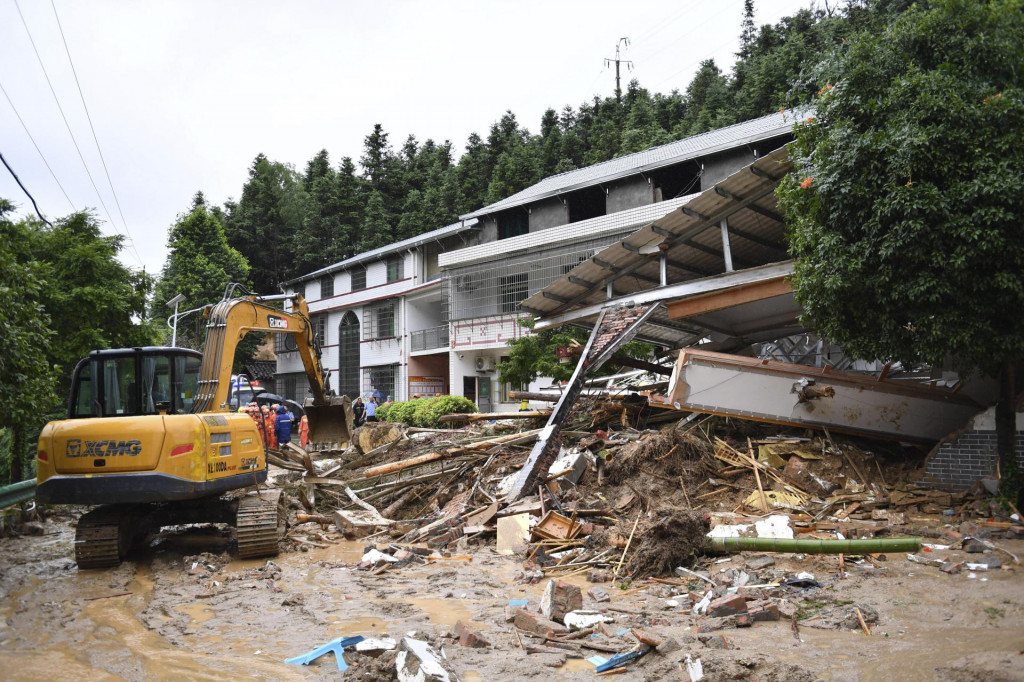 Bagrista odstraňuje materiálne škody v blízkosti zrútenej budovy po zosuve pôdy v dedine Jüe-lin v provincii Chu-nan v strednej časti Číny. FOTO: TASR/AP