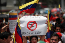 Protest proti výsledkom volieb, ktoré udelili venezuelskému prezidentovi Nicolasovi Madurovi tretie funkčné obdobie. Žena drží plagát s nápisom: „Maduro von“ a „Oslobodiť Venezuelu“. FOTO: Reuters