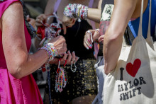 Fanúšikovia americkej speváčky Taylor Swiftovej predávajú náramky v centre Viedne. FOTO: TASR/AP