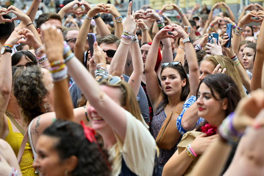 Fanúšikovia speváčky Taylor Swift vytvárajú tvar srdca rukami, keď sa zhromažďujú po zrušení troch koncertov Taylor Swift. FOTO: Reuters
