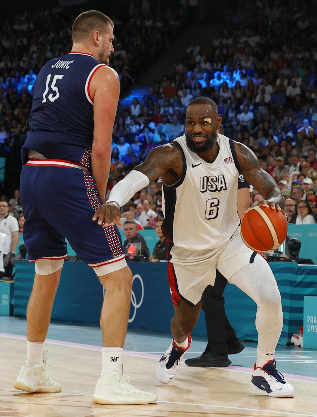Lebron James zo Spojených štátov v akcii s Nikolom Jokičom zo Srbska. FOTO: Reuters