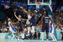 Bilal Coulibaly (99) z Francúzska, Devin Booker (15), Guerschon Yabusele (7) z Francúzska a Bam Adebayo (13) z USA bojujú o držanie lopty počas basketbalového zápasu mužov o zlatú medailu v Bercy Arene v hale. FOTO: TASR/AP