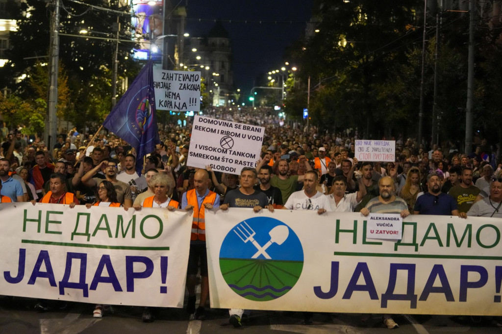 Ľudia držia transparenty a pochodujú počas protestu proti projektu na ťažbu lítia v Srbsku. FOTO: TASR/AP