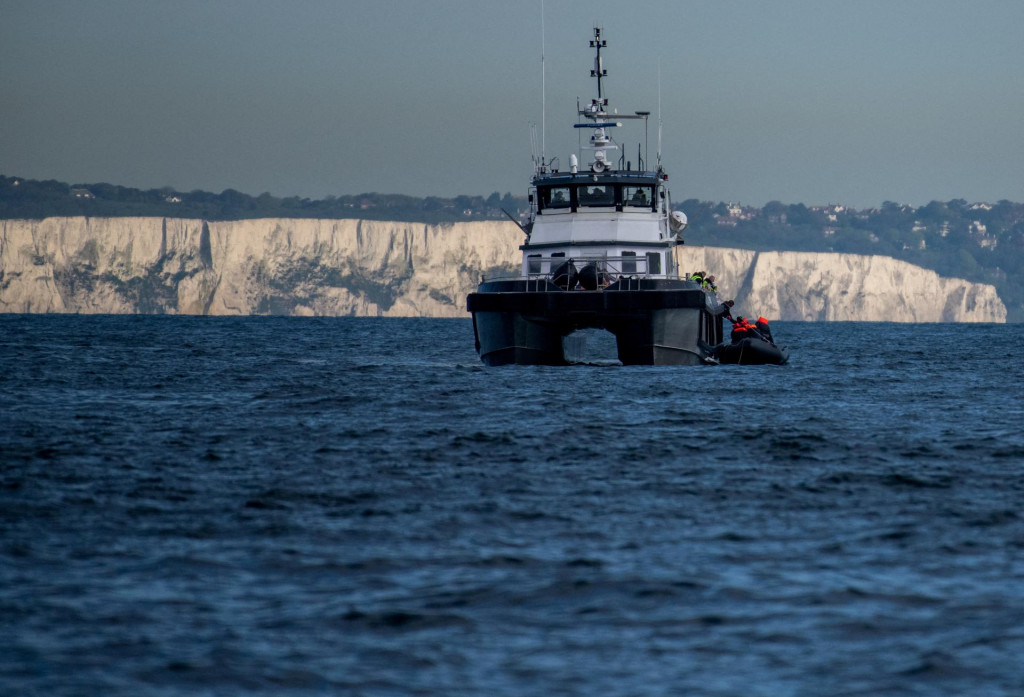 Plavidlo britských pohraničných síl zachytáva nafukovací čln s migrantmi pred bielymi útesmi Doveru v Lamanšskom prielive. FOTO: Reuters