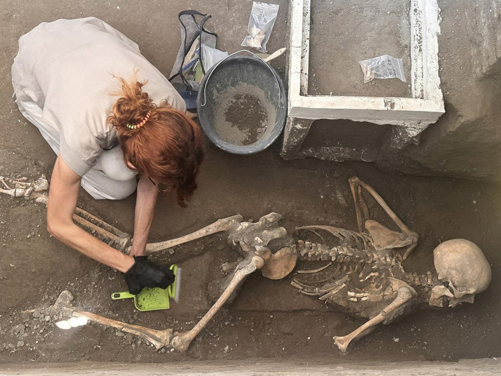 Archeológ pracuje na nedávno objavených pozostatkoch obete v archeologickom nálezisku starovekého mesta Pompeje, ktoré bolo zničené v roku 79 n.l. pri erupcii sopky Vezuv. FOTO: Reuters/Archeologický park Pompeje