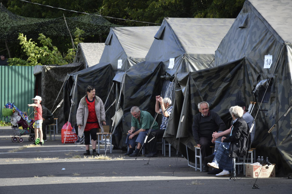 Evakuovaní ľudia sedia pri stanoch v dočasnom stanovom tábore v meste Kursk na západe Ruska. FOTO: TASR/AP