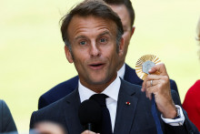 Francúzsky prezident Emmanuel Macron drží olympijskú medailu. FOTO: REUTERS