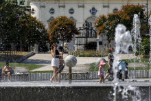 Ľudia sa ochladzujú vo fontáne na Námestí slobody počas horúčav v Bratislave