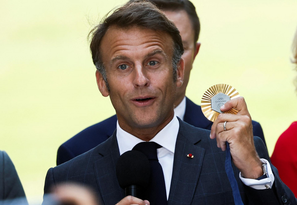 Francúzsky prezident Emmanuel Macron drží olympijskú medailu. FOTO: REUTERS