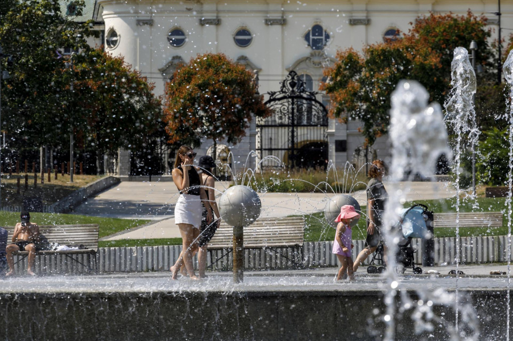 Ľudia sa ochladzujú vo fontáne na Námestí slobody počas horúčav v Bratislave. FOTO: TASR/Dano Veselský