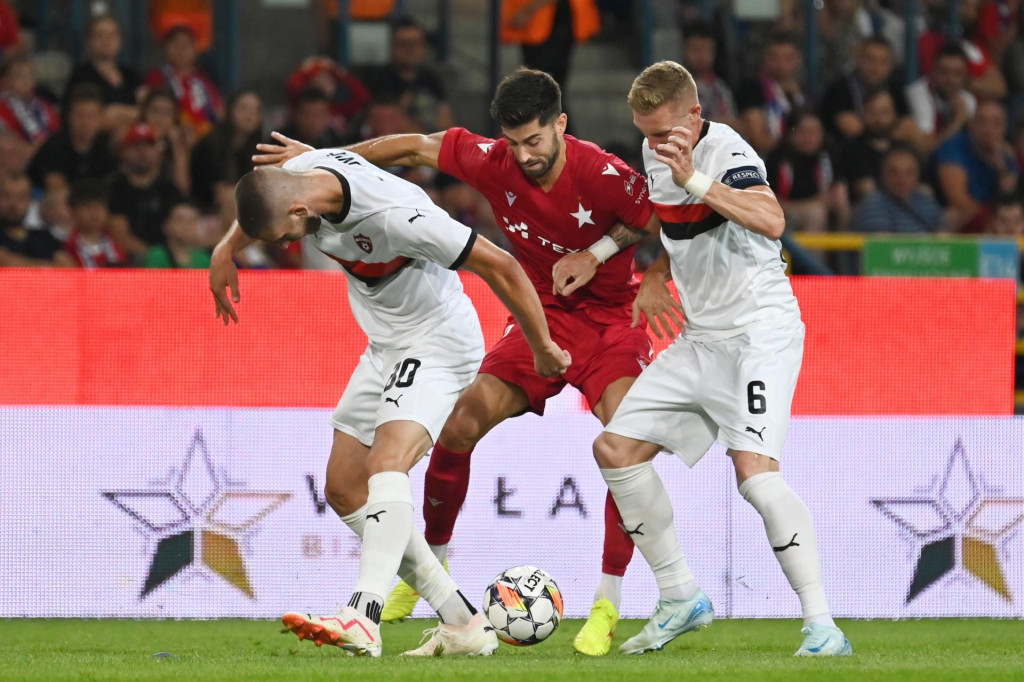 Hráč Trnavy Adrian Zelkovič, hráč Krakova Marc Carbo a kapitán Trnavy Roman Procházka počas odvetného zápasu tretieho predkola Európskej konferenčnej ligy medzi Wisla Krakov - FC Spartak Trnava. FOTO: TASR/Lukáš Grinaj