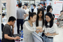 Ľudia sa zúčastňujú na veľtrhu práce v nákupnom centre v čínskom Pekingu. FOTO: REUTERS