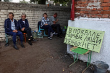 Ruskí miestni obyvatelia sedia v blízkosti krytu, kde sa ukrývali počas nedávnych bojov medzi ukrajinskými a ruskými silami v meste Sudža. FOTO: Reuters