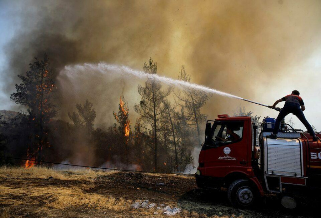 Hasič hasí niekoľko hektárov lesa. FOTO: Reuters