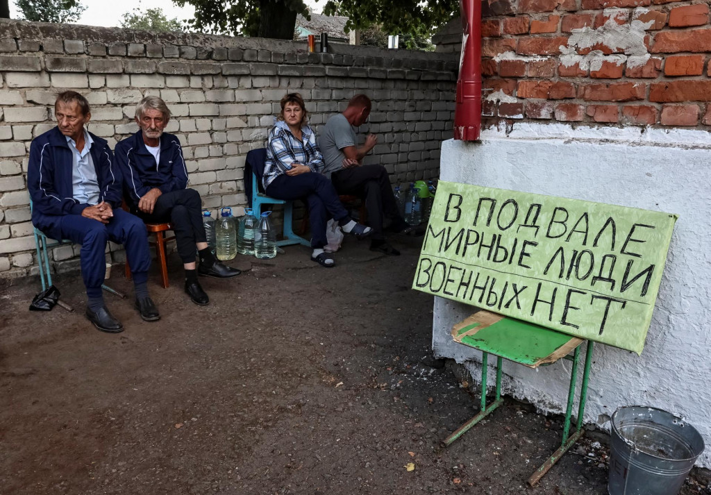 Ruskí miestni obyvatelia sedia v blízkosti krytu, kde sa ukrývali počas nedávnych bojov medzi ukrajinskými a ruskými silami v meste Sudža. FOTO: Reuters