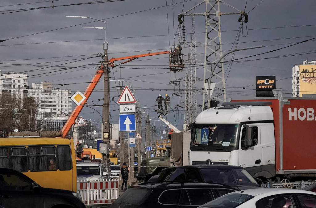 Pracovníci zásobovania energiou obnovujú vedenie vysokého napätia zničené pri ruskom raketovom útoku. FOTO: Reuters