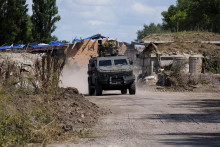 Ukrajinskí vojaci sedia na obrnenom vozidle v Sumskej oblasti. FOTO: TASR/AP