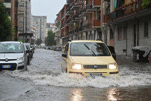 Na snímke auto jazdí po zaplavenej ceste v meste Turín na severe Talianska 14. augusta 2024. Silné búrky a vietor spôsobili záplavy, ulice a cesty lemovali polámané stromy.