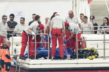 Talianski potápači vynášajú telo jednej z obetí potopenej plachetnice Bayesan v prístave v meste Porticello neďaleko Palerma na talianskom ostrove Sicília. FOTO: TASR/AP