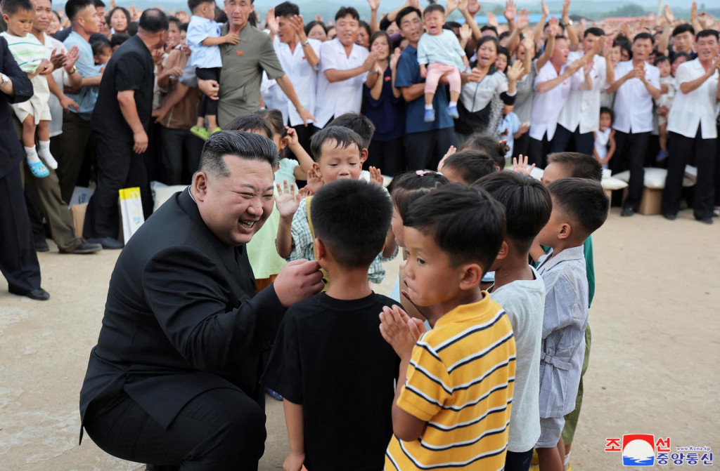 Ilustračná fotografia. Severokórejský vodca Kim Čong-un zdraví deti počas návštevy záplavami postihnutej oblasti okresu Uiju. FOTO: Reuters/KCNA