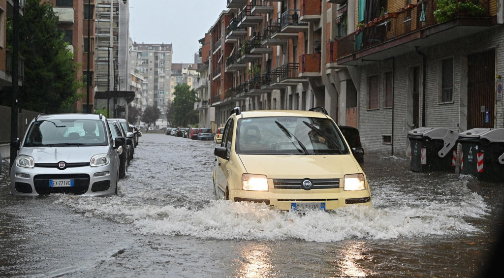 Na snímke auto jazdí po zaplavenej ceste v meste Turín na severe Talianska 14. augusta 2024. Silné búrky a vietor spôsobili záplavy, ulice a cesty lemovali polámané stromy.