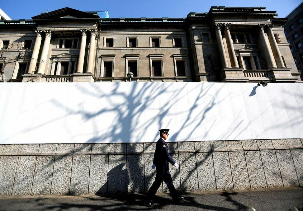 Pred centrálou Bank of Japan v Tokiu v Japonsku prechádza ochranka. FOTO: Reuters