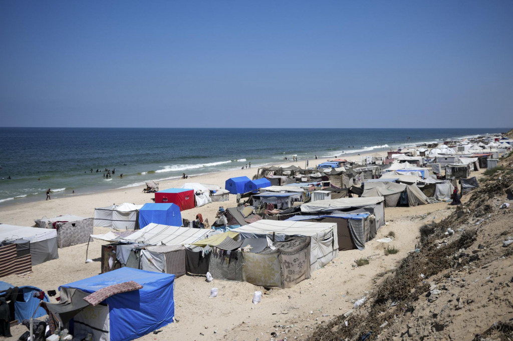 Palestínčania bez strechy nad hlavou kempujú v stanoch rozmiestnených v utečeneckom tábore na pláži, západne od mesta Dajr al-Balah, v Pásme Gazy. FOTO: TASR/AP