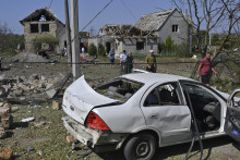 Ľudia kráčajú okolo zničených domov po ruskom raketovom útoku na dedinu Usatove neďaleko Odesy na juhu Ukrajiny. (26. augusta). FOTO: TASR/AP